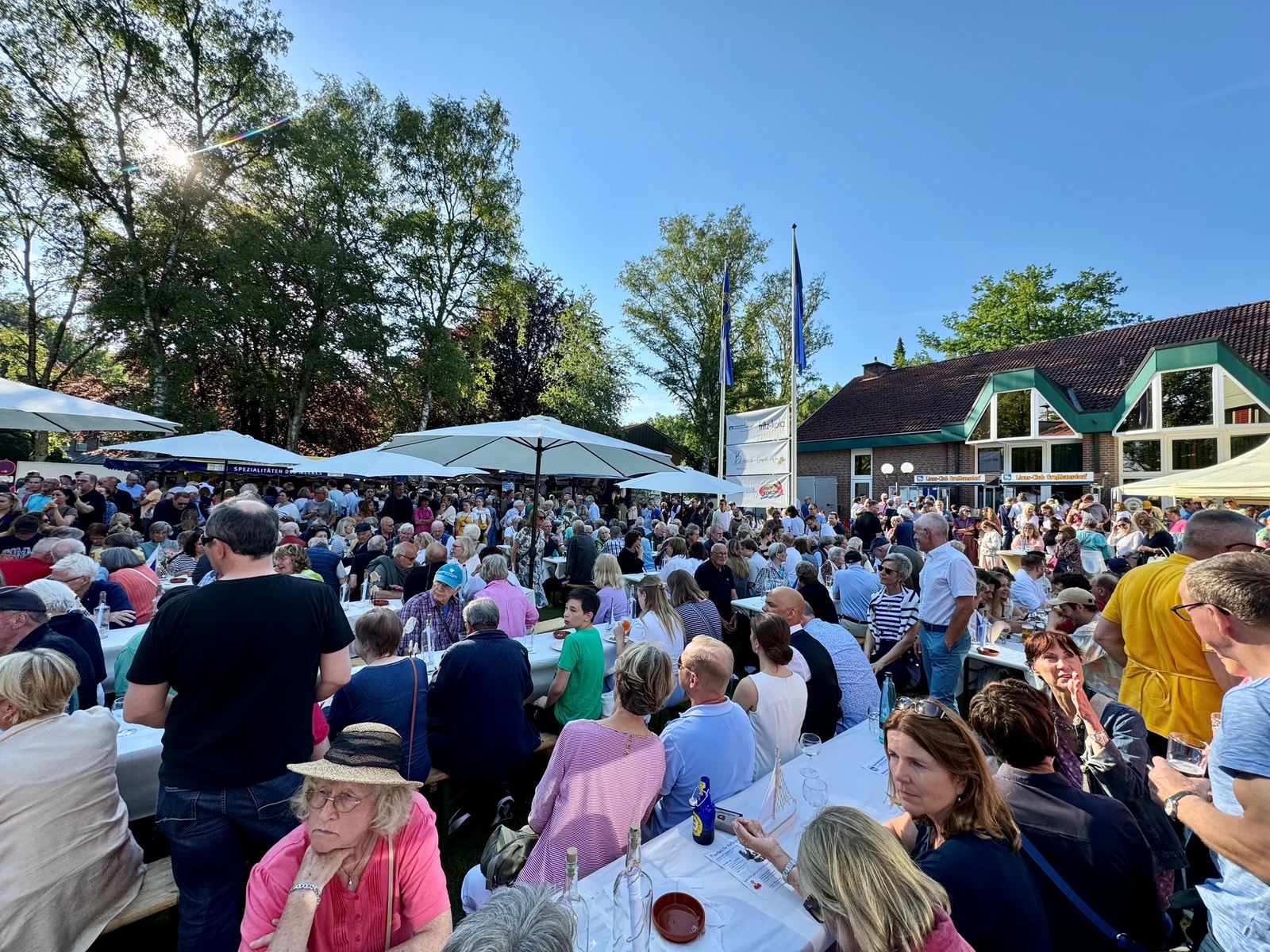 Gäste an langen Tischen auf dem Rathausplatz beim Matjesfest