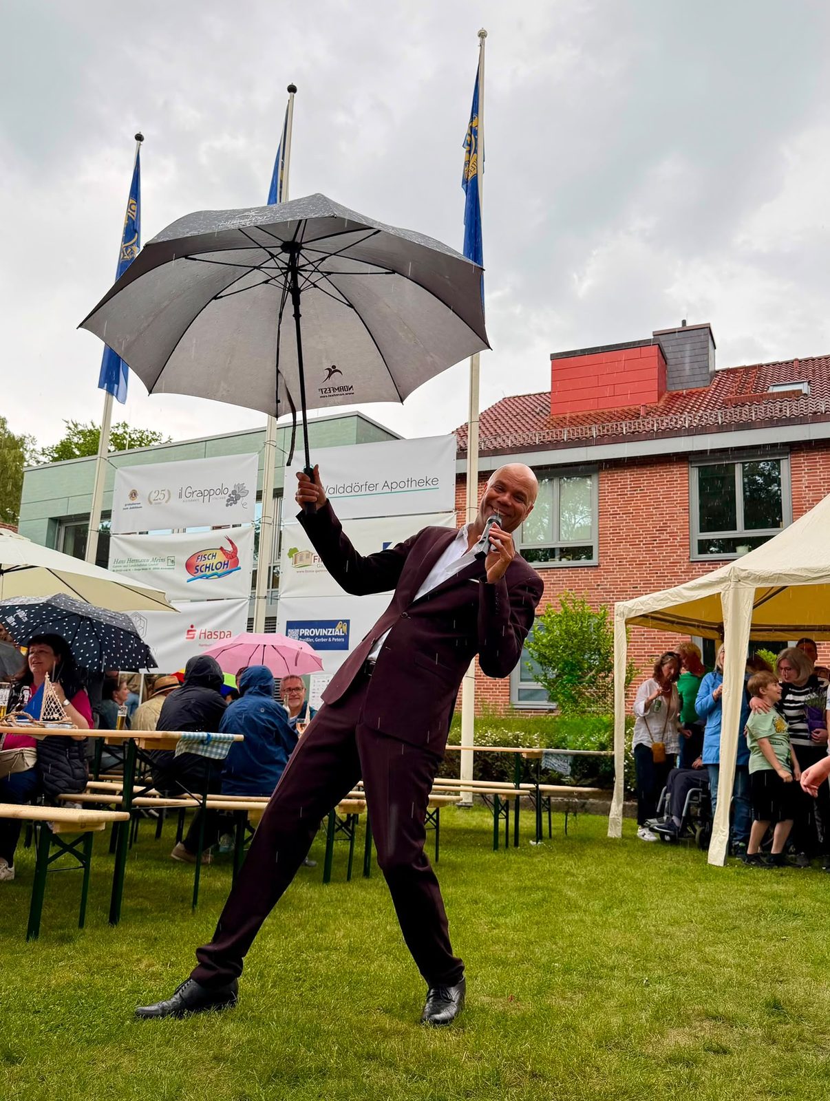 Sänger mit Regenschirm und Mikrofon auf dem Rathausplatz